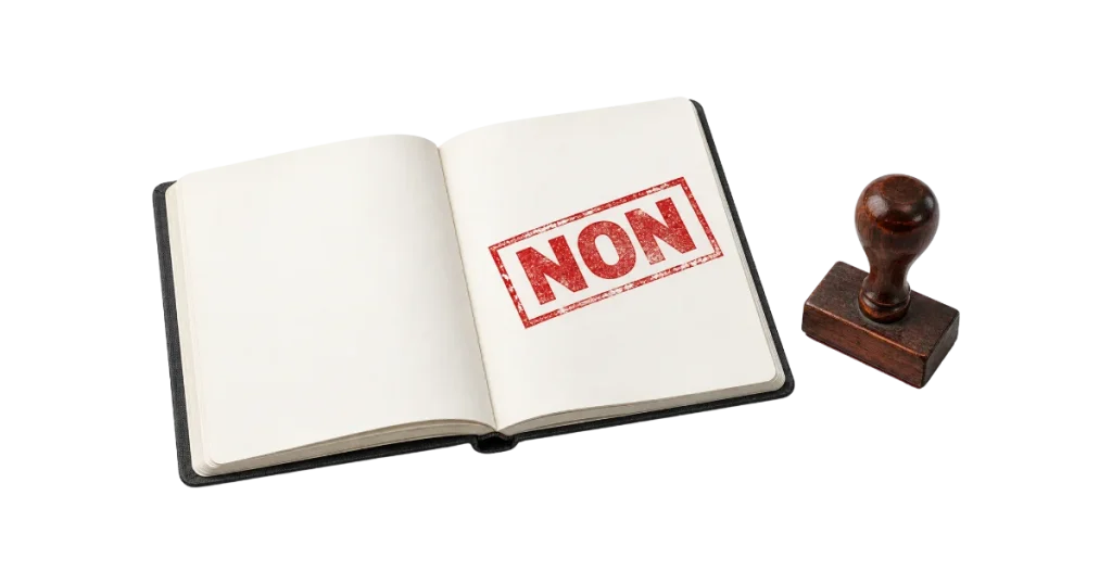 Carnet ouvert tamponné d'un NON rouge à côté d'un tampon en bois, image du réflexe de refus au cœur du dilemme de l'innovation
